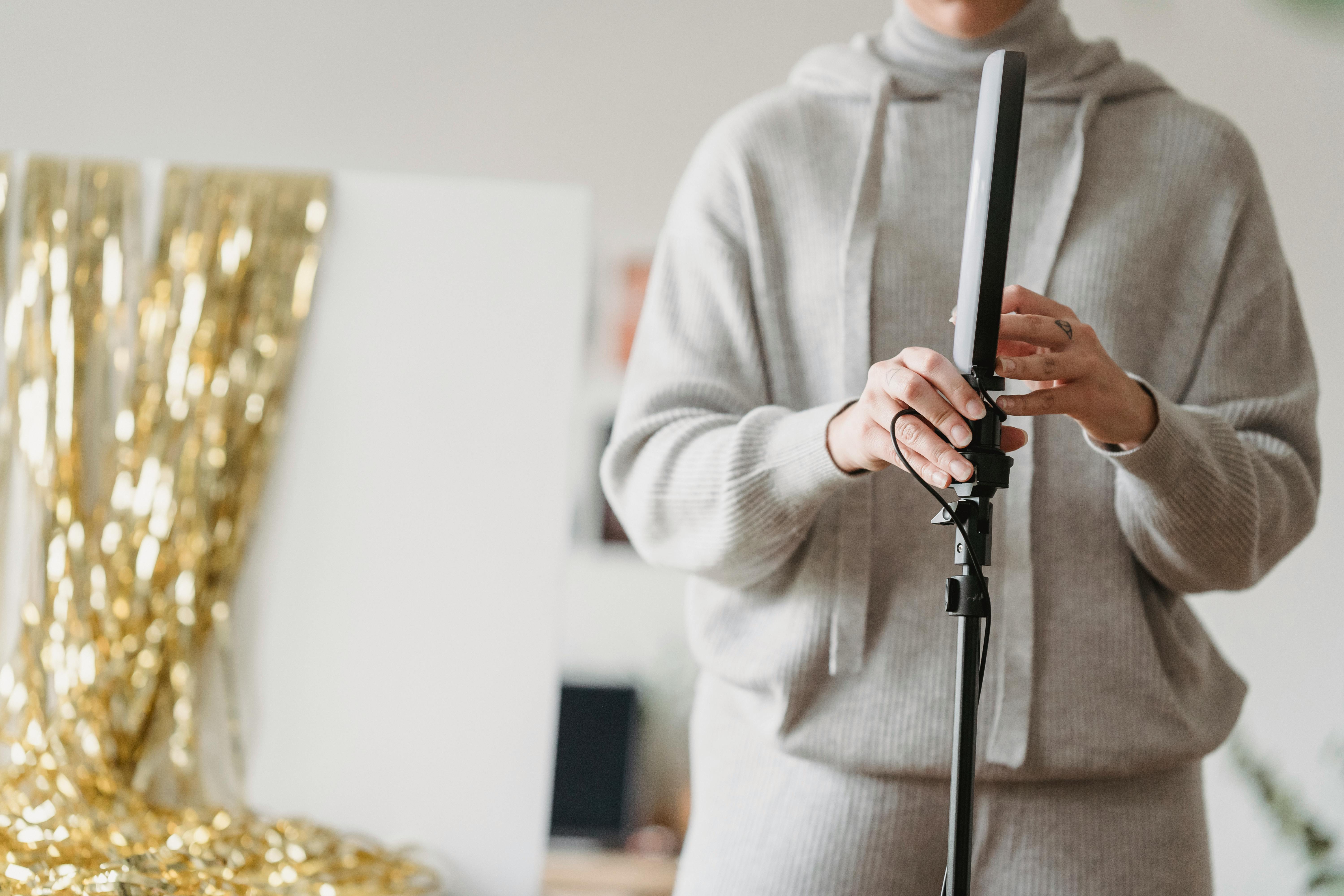 crop unrecognizable woman placing ring light in living room