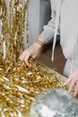 Faceless woman at table with golden tinsel in room