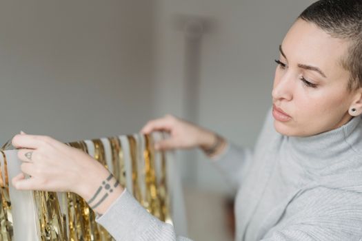 Crop focused woman with tattoos and tinsel indoors
