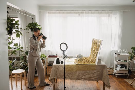 Photographer taking photo of tinsel on digital camera at home