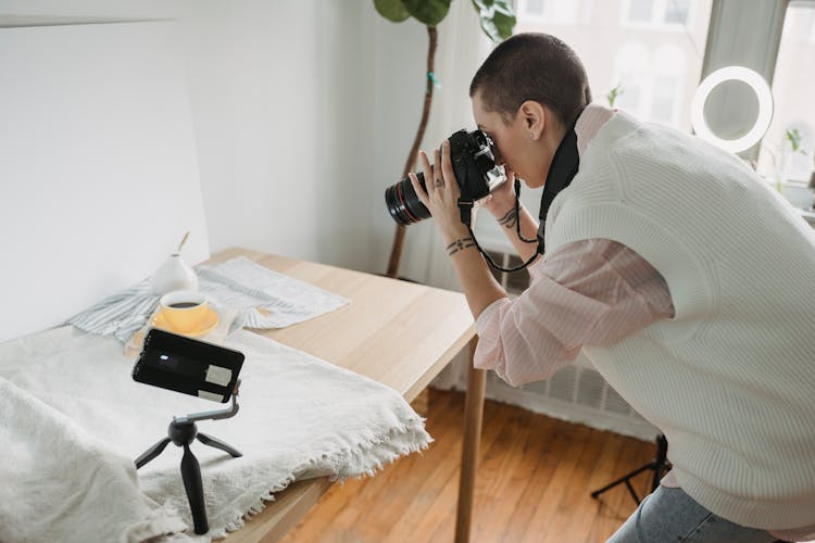 Focused Photographer Taking Photo Of Coffee On Digital Camera Indoors