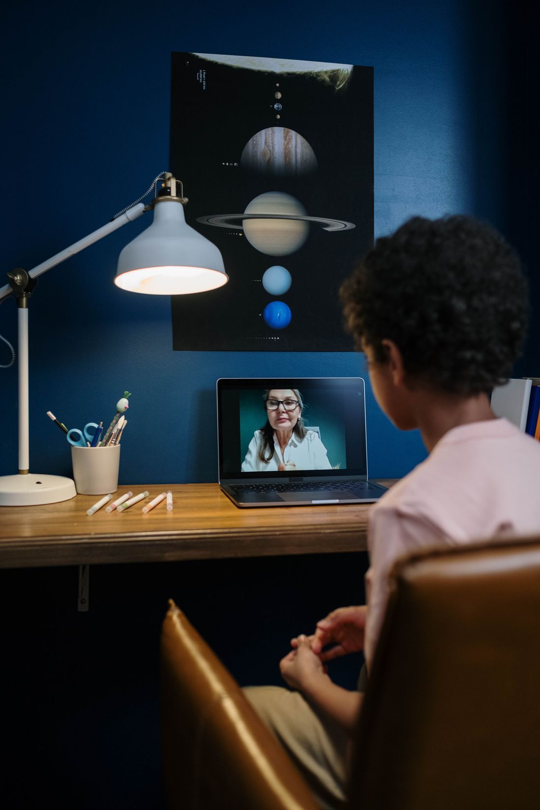 Child engaged with an online class on a laptop