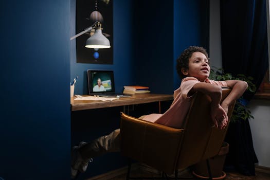 A young student relaxes while learning online in a cozy home study setup.