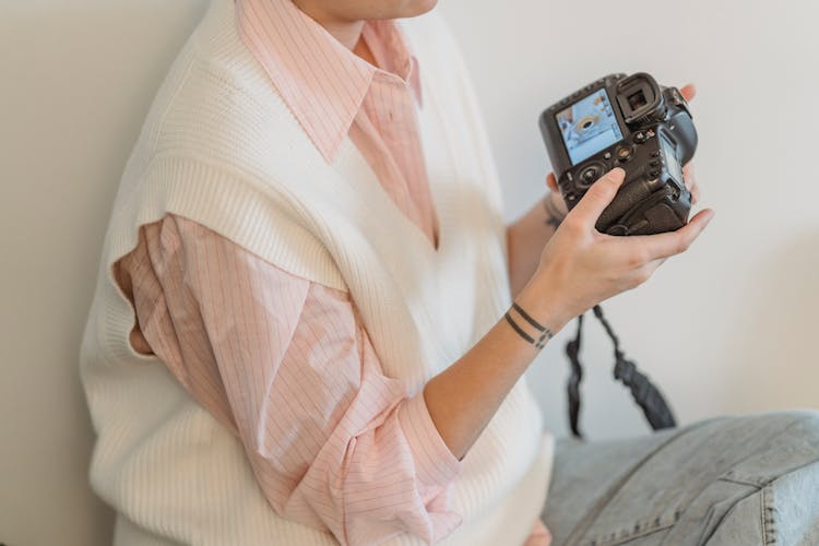 Crop Unrecognizable Woman Looking At Photos In Camera