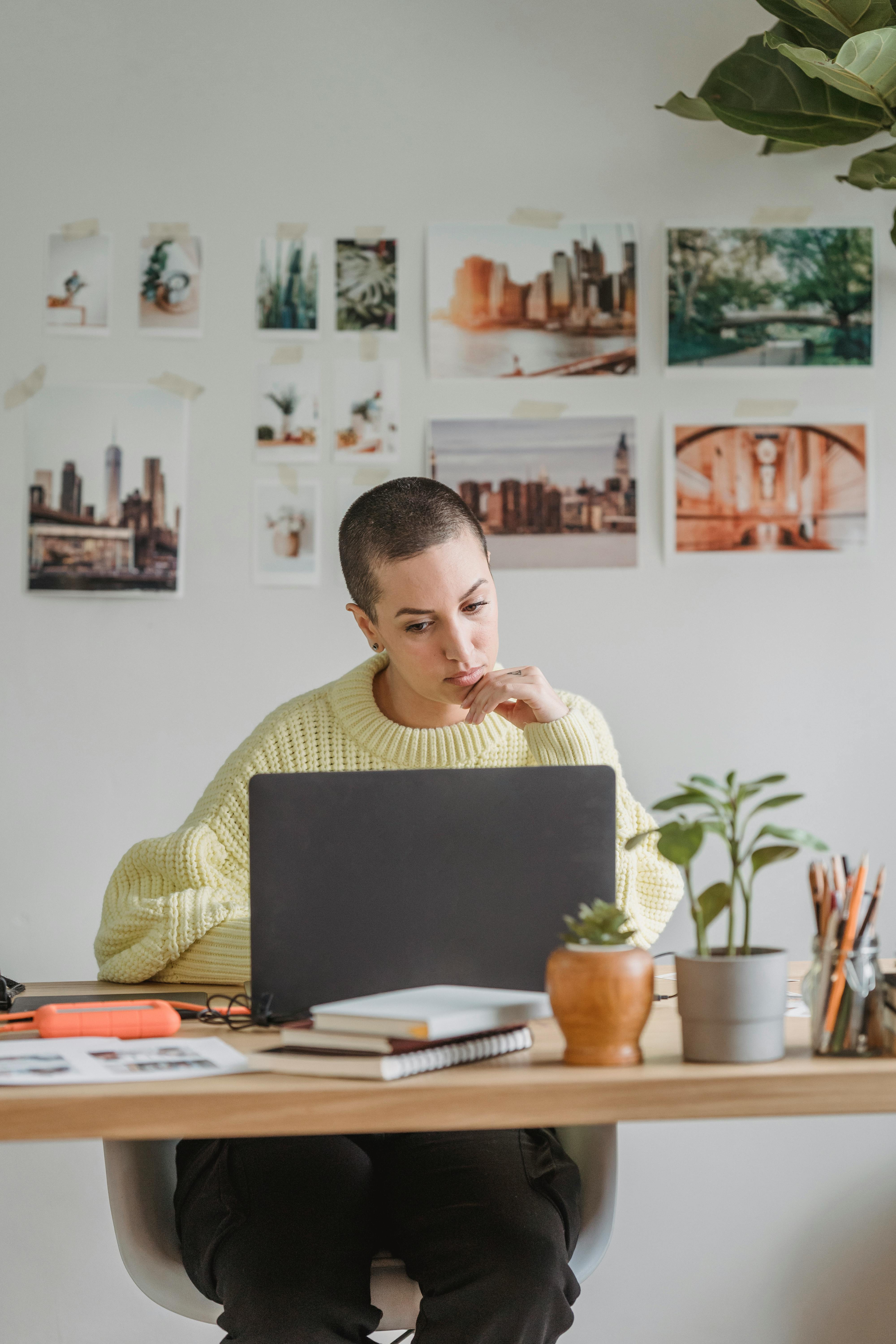 pensive woman working on laptop in light room