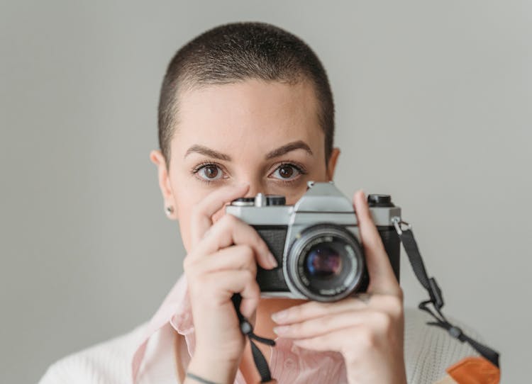 Unemotional Woman Taking Photos On Professional Camera