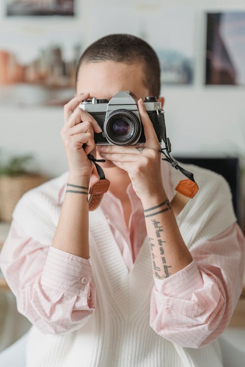 Woman taking photos on professional camera at home