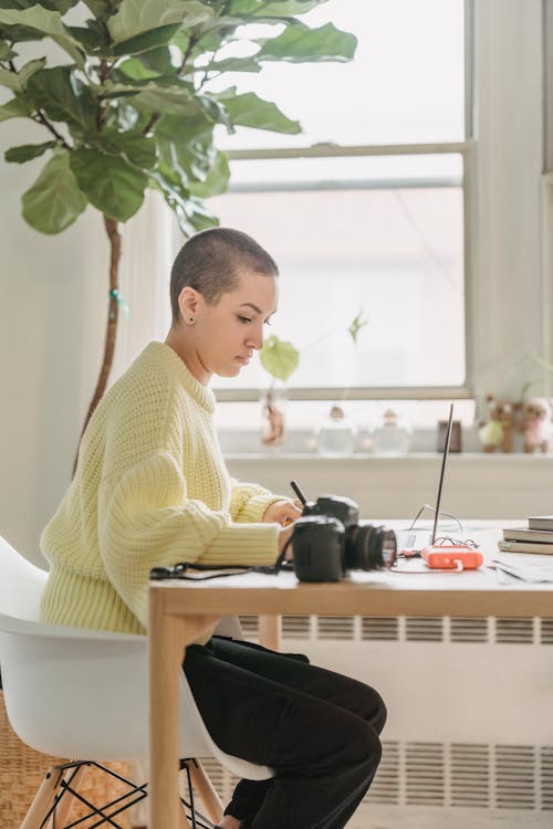 Serious photographer working at table with laptop