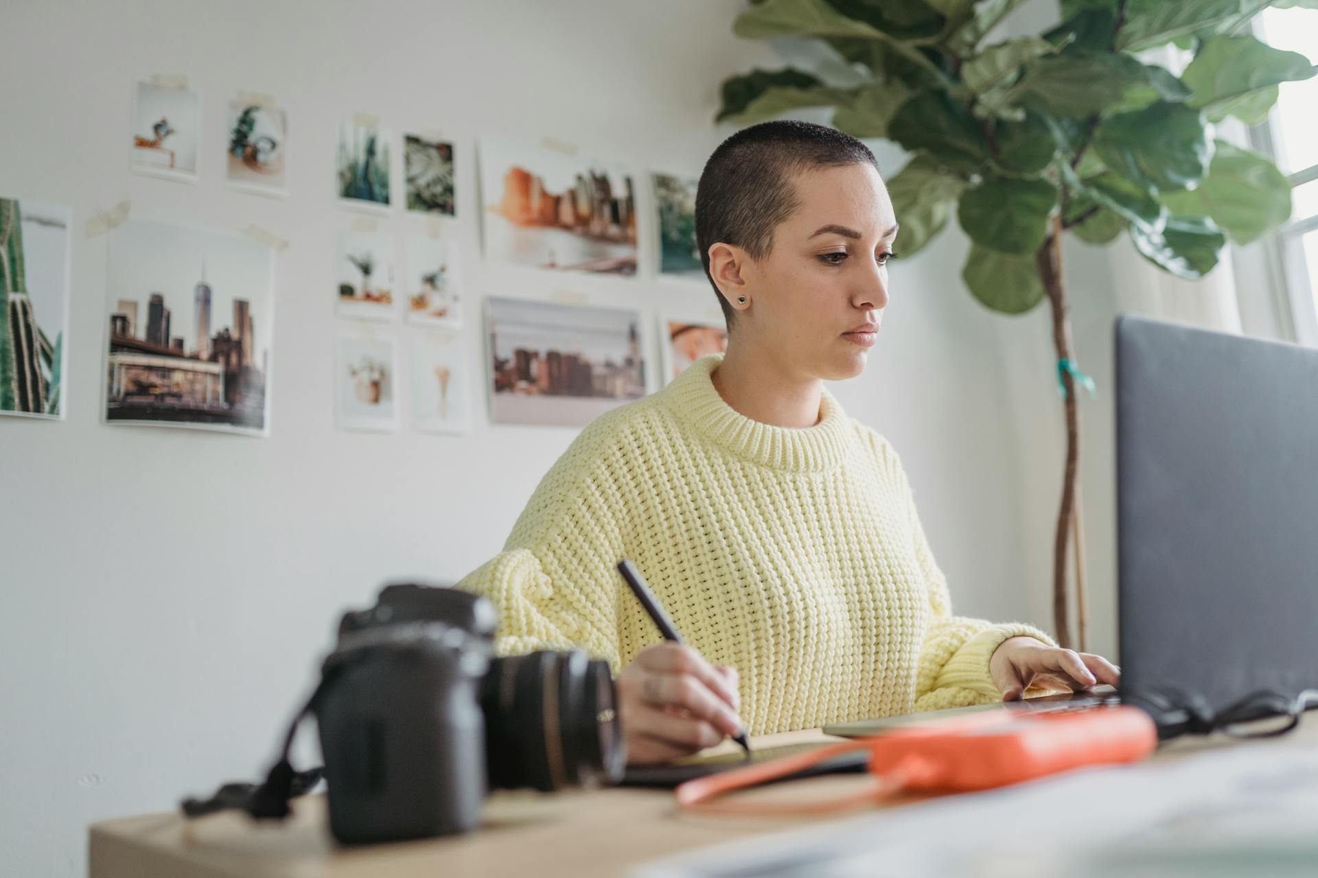 Focused woman drawing on graphic tablet while editing photos