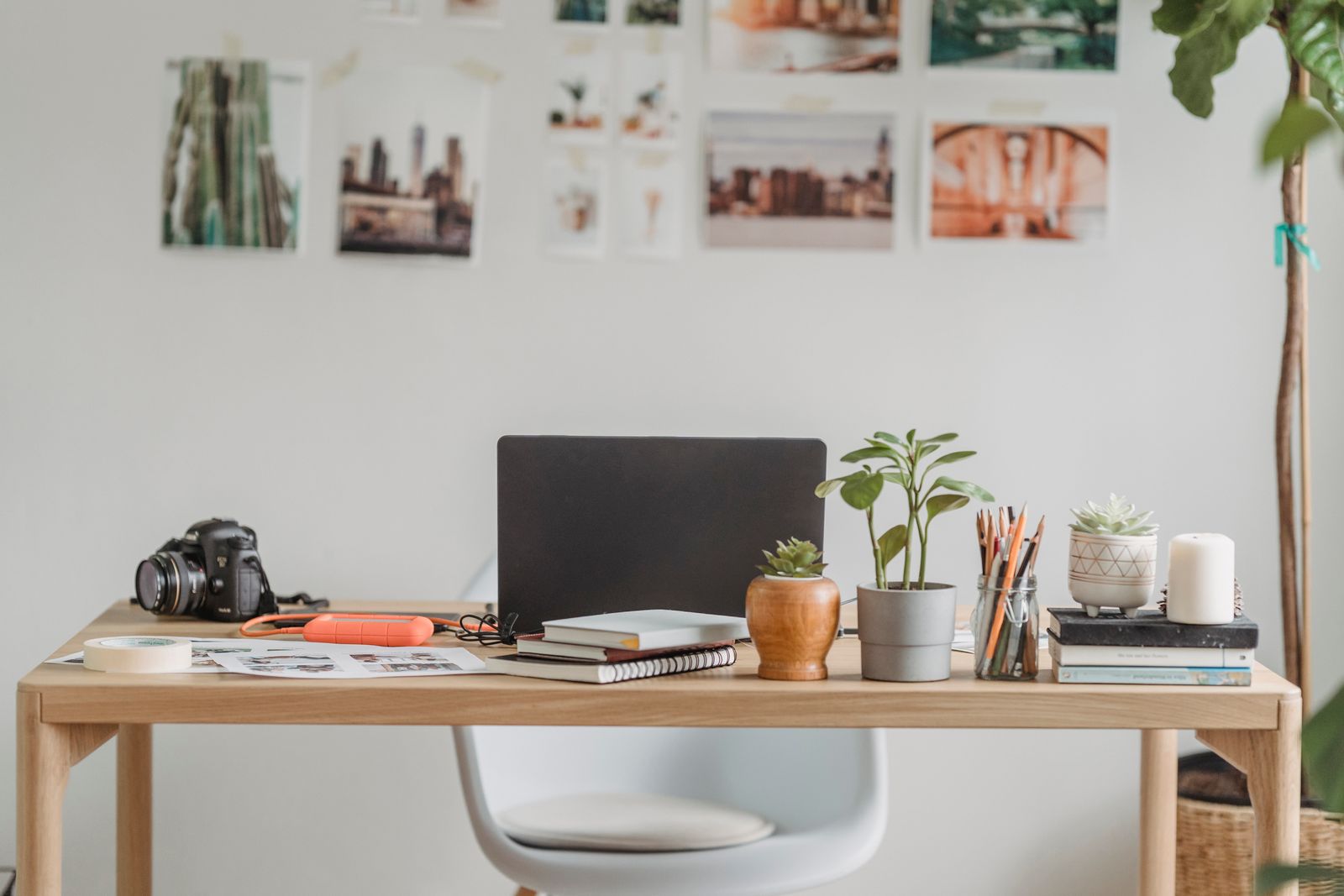 Studio desk with camera, notebooks and pinned reference prints — photo by George Milton on Pexels