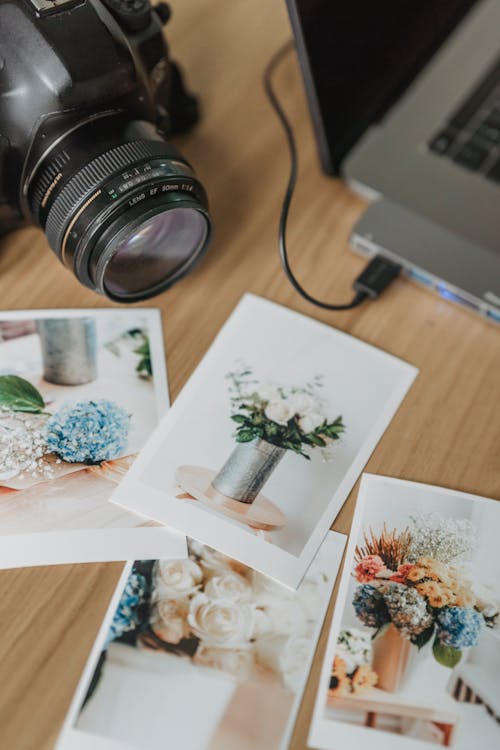 Printed photos on table with photo camera