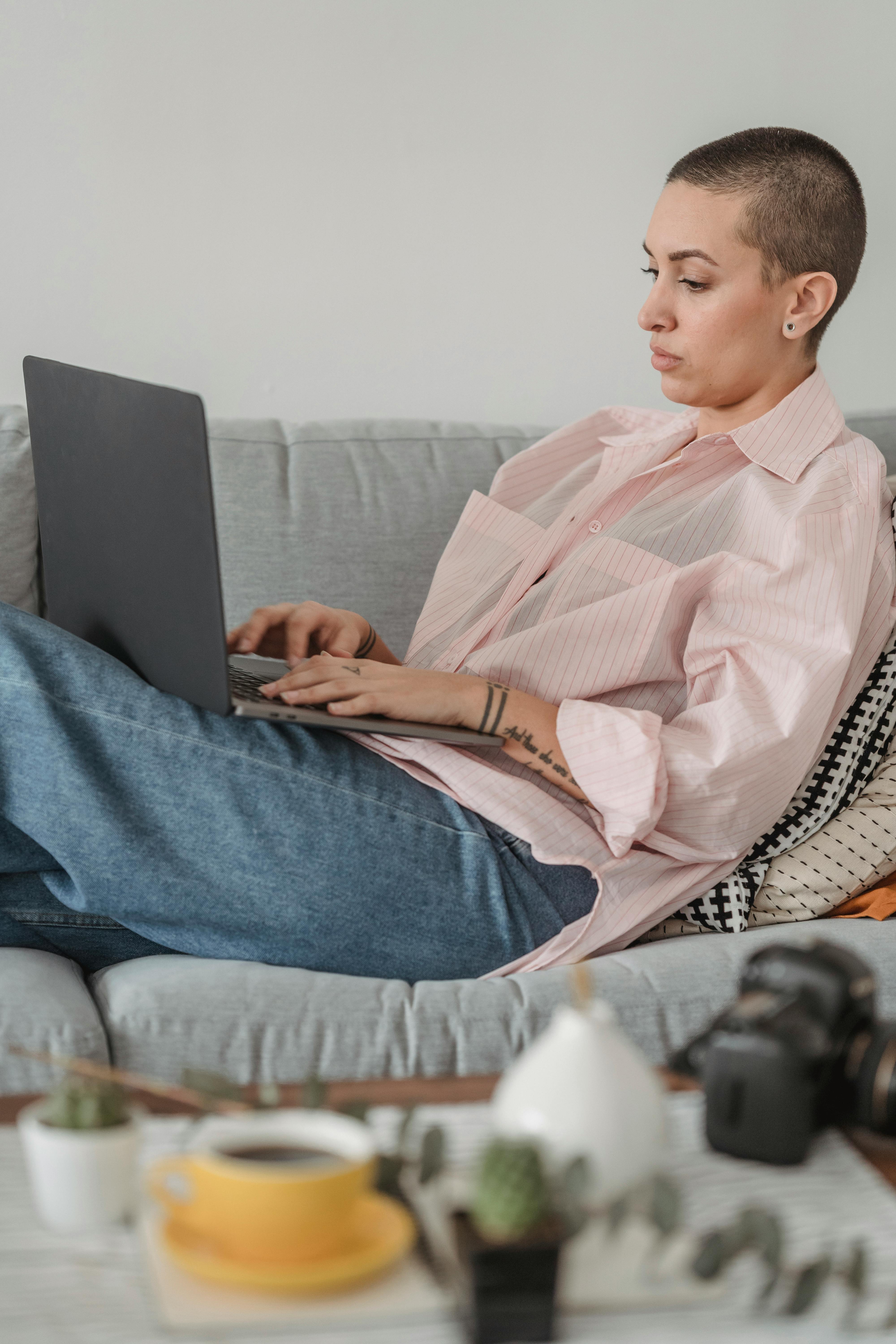 serious photographer browsing laptop on couch