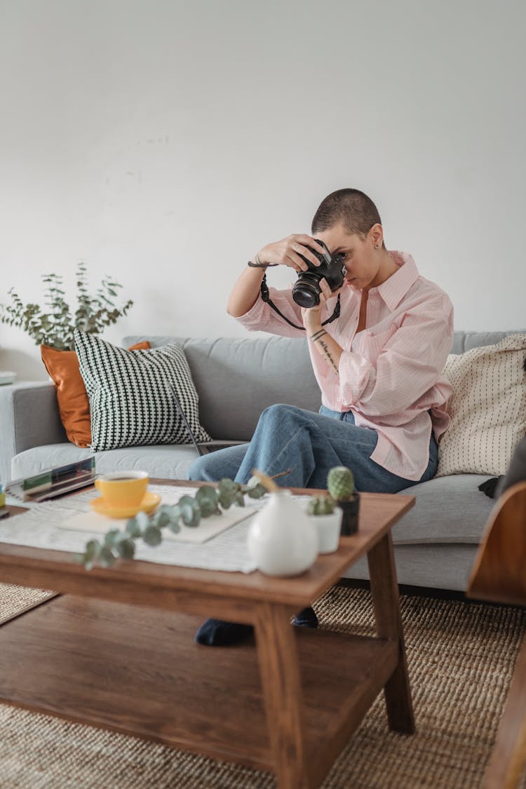 Focused Woman Taking Photo Of Green Twig With Cup Of Tea