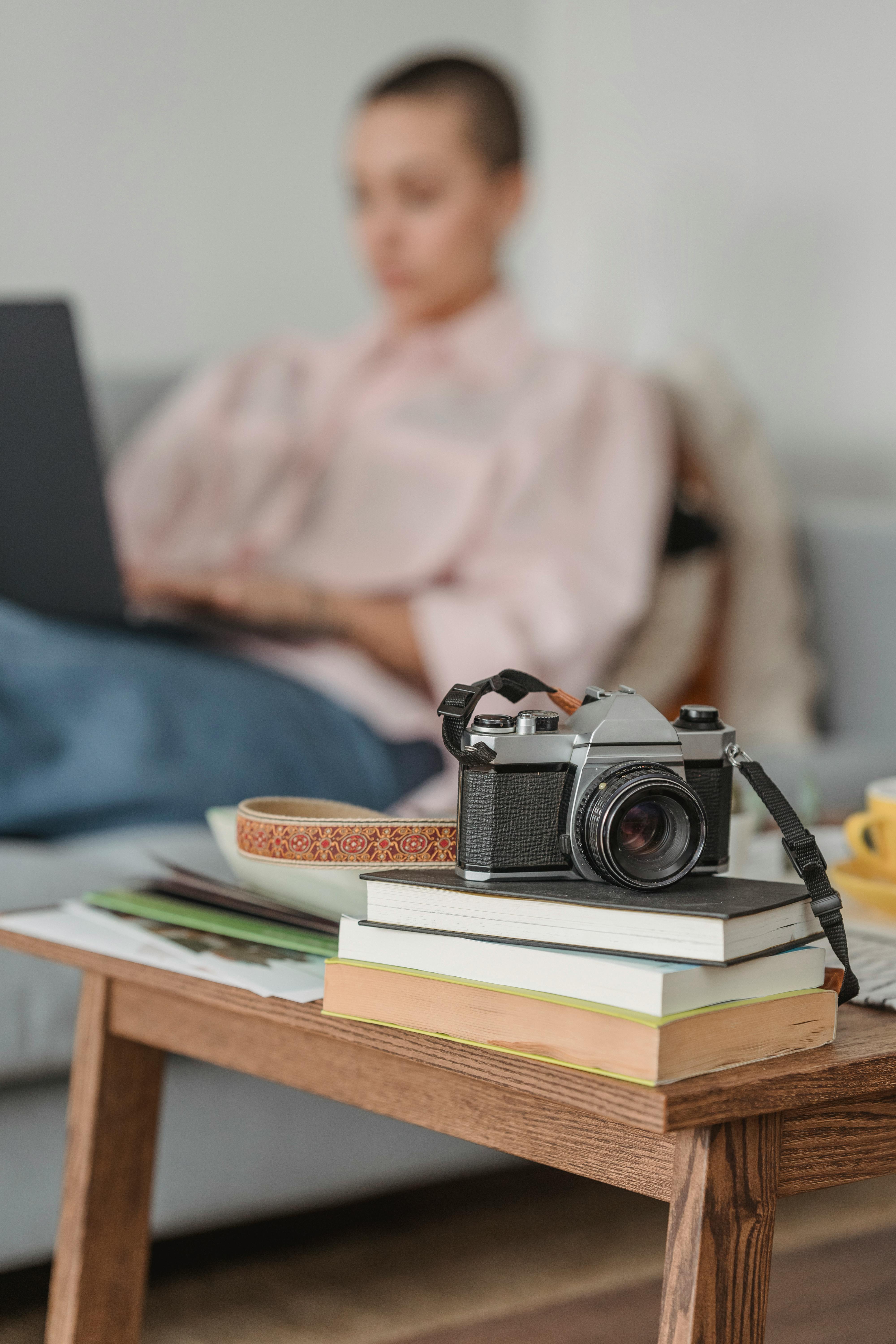 woman working on laptop near coffee table with photo camera