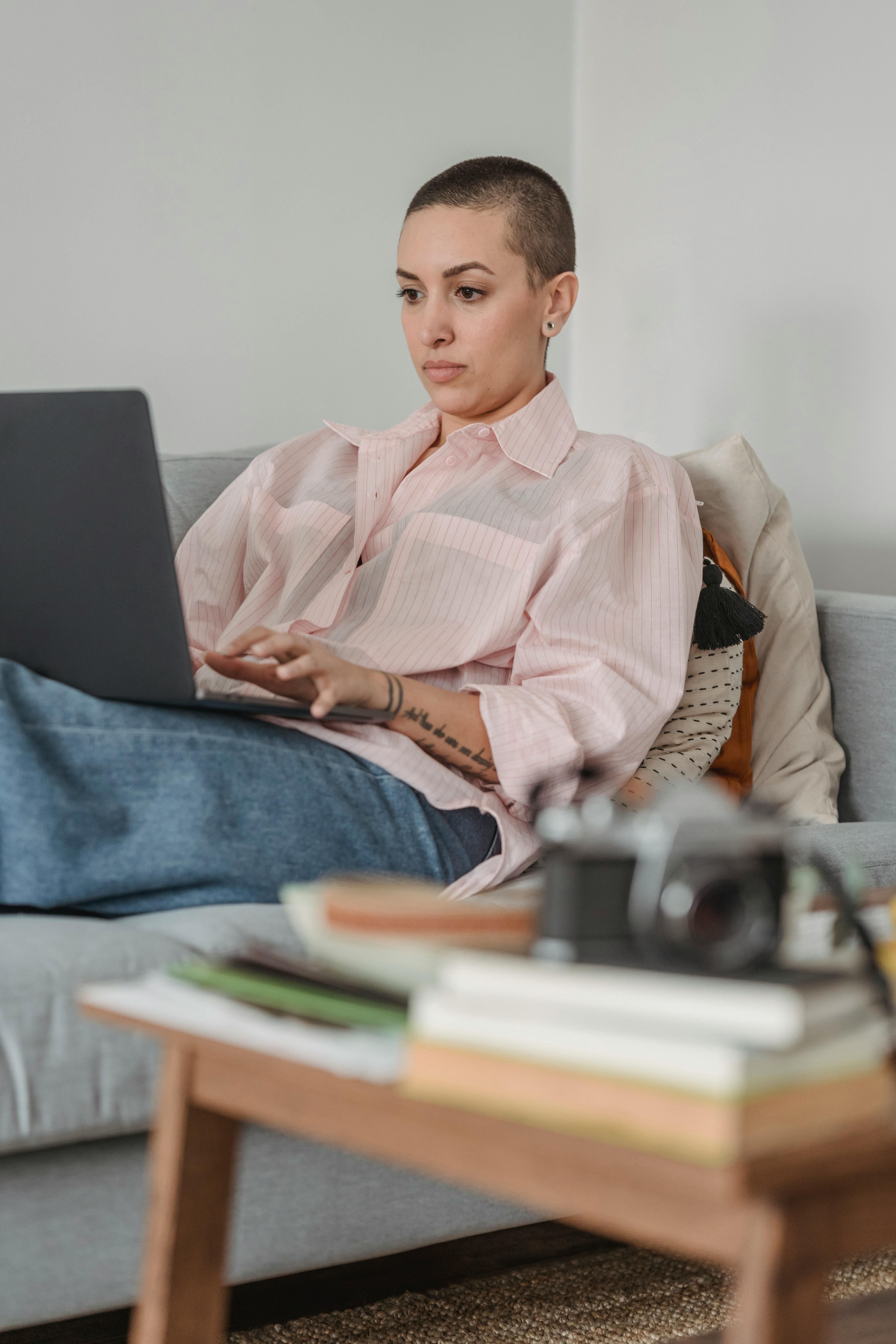 focused woman working on laptop on cozy sofa