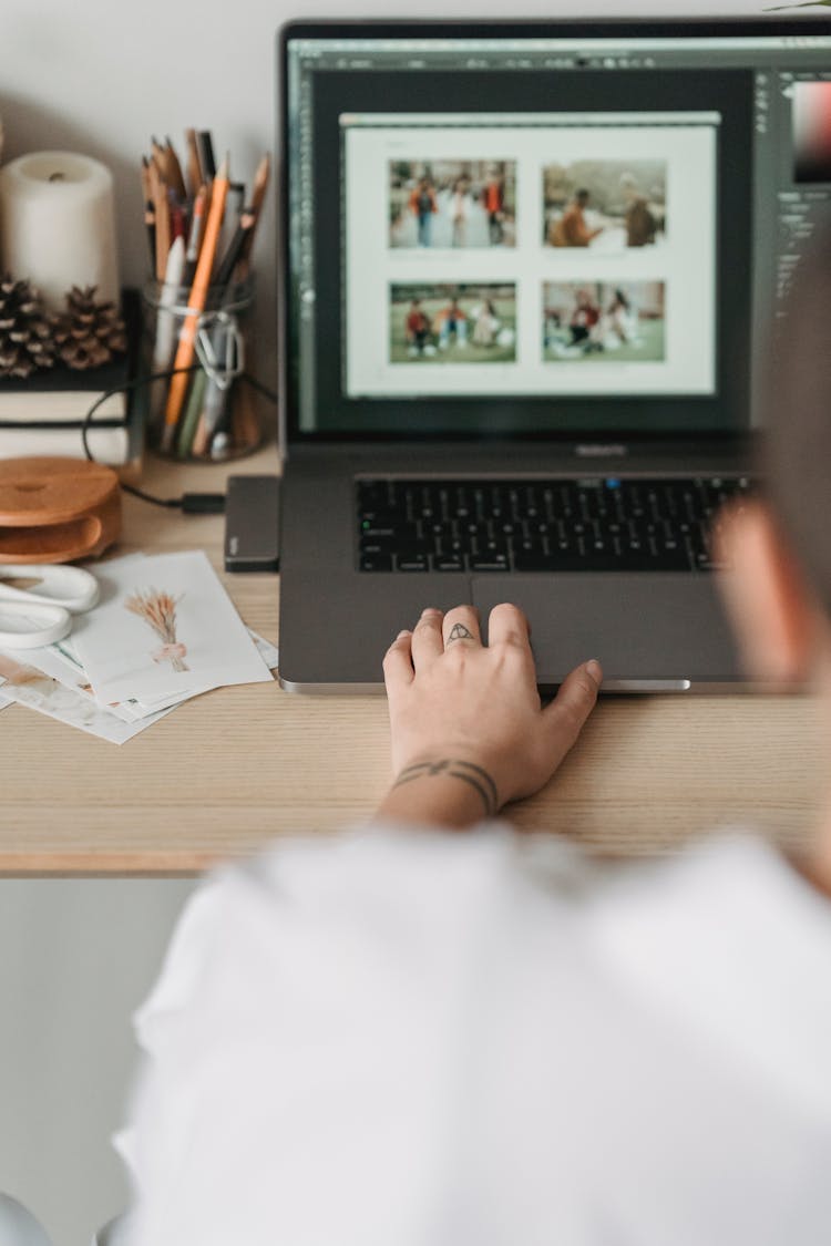 Crop Faceless Person Editing Photos On Laptop