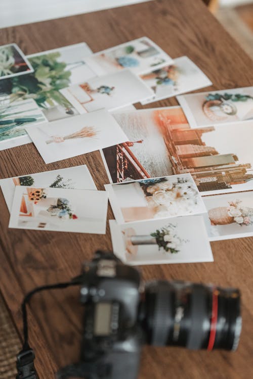 Printed photos scattered on wooden table