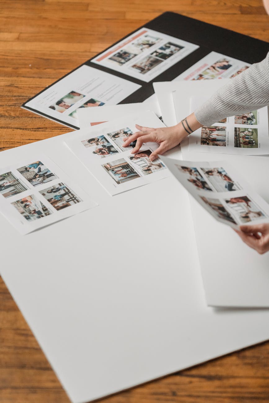 Creative arrangement of printed photos on a wooden floor, showcasing a photography project.