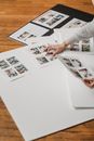 Crop unrecognizable person creating photo collage on floor