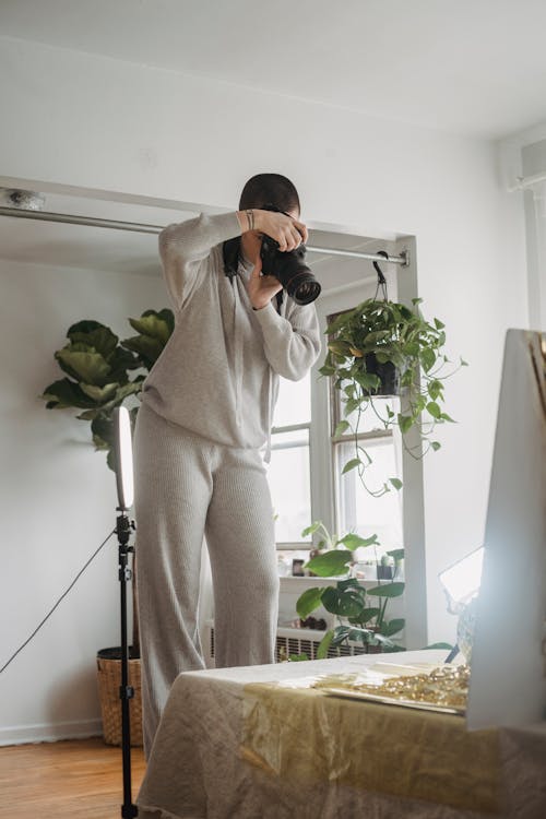 Faceless woman taking photos in studio