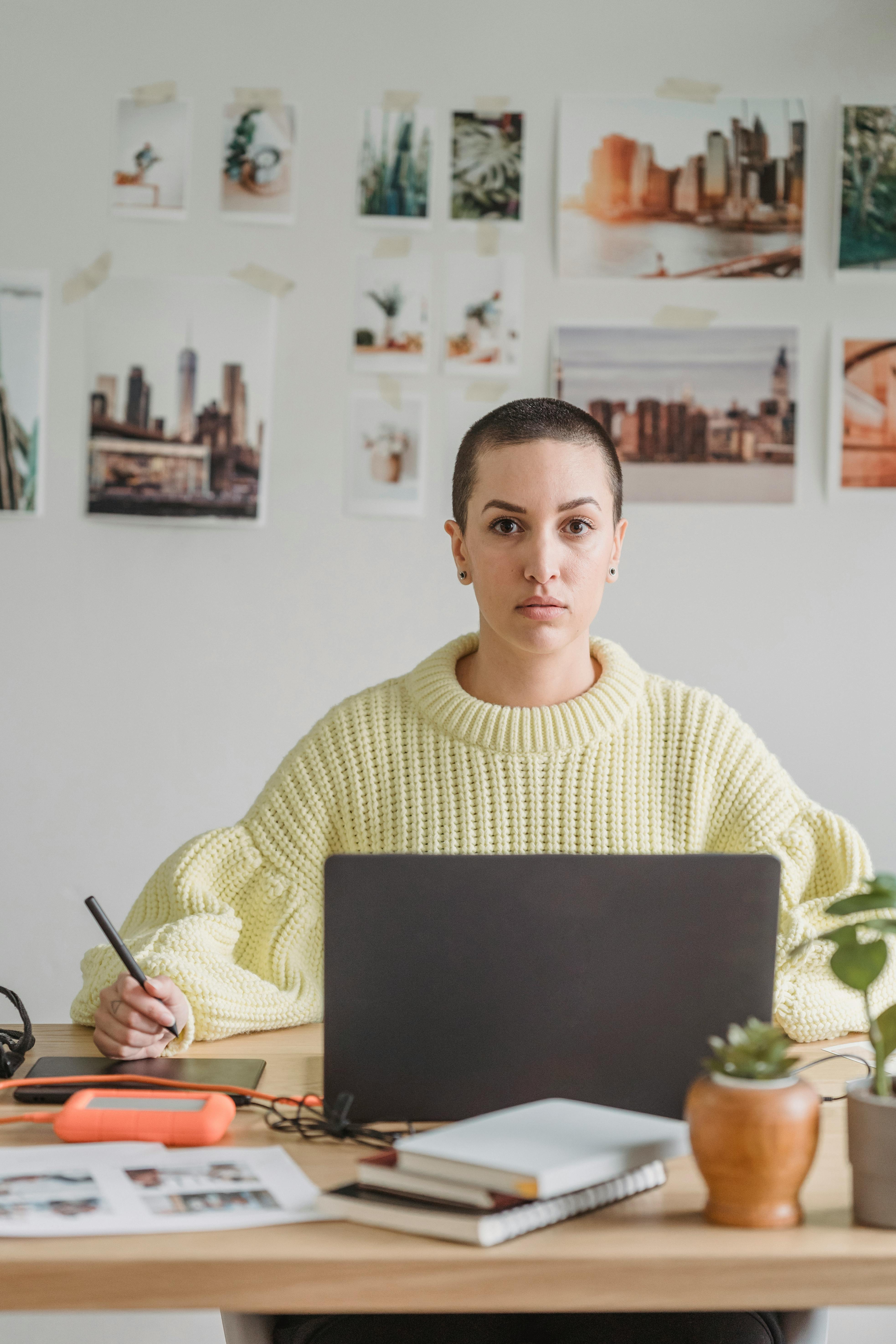 thoughtful female designer with laptop and graphic tablet