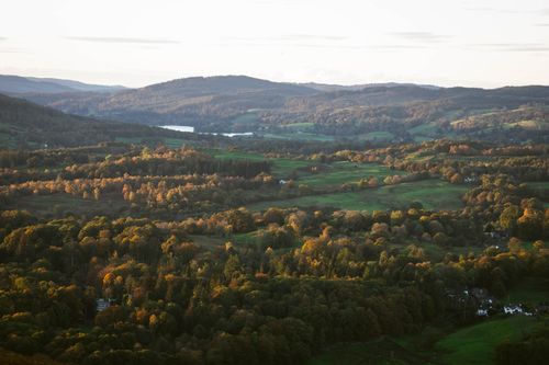 Free Aerial photography captures serene forest and valleys during sunset, showcasing scenic nature and vibrant autumn colors. Stock Photo