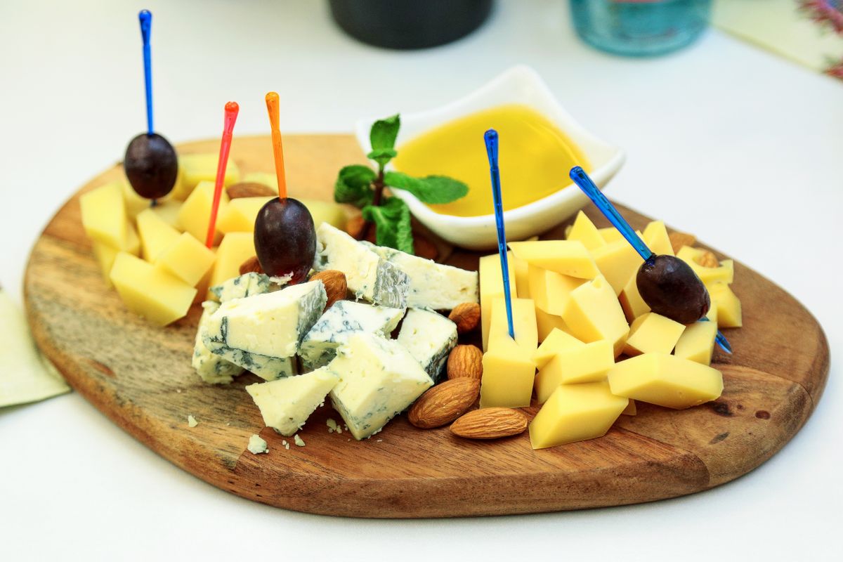 Gourmet cheese board with assorted cheeses, grapes, and almonds