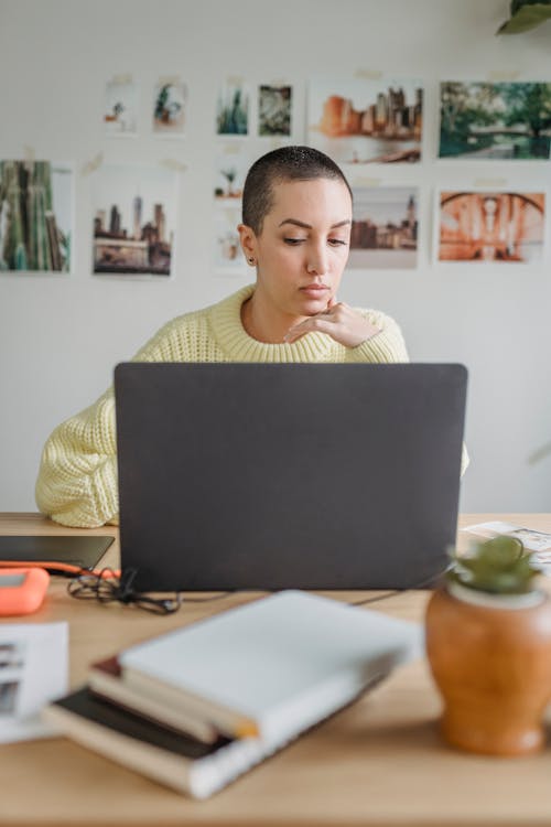 Free Serious woman working on laptop at home Stock Photo