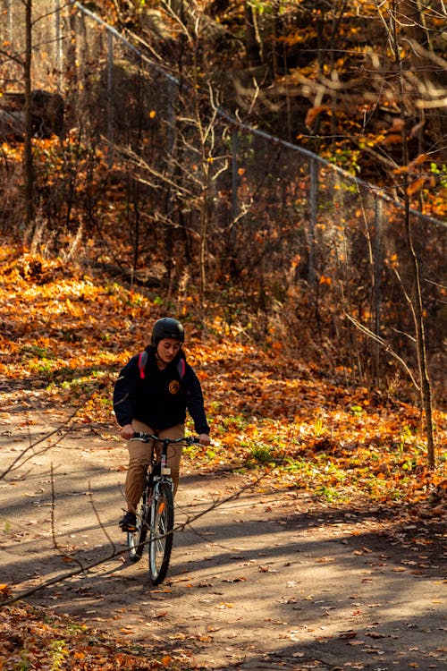 Man in Black Jacket Riding Bicycle on Road