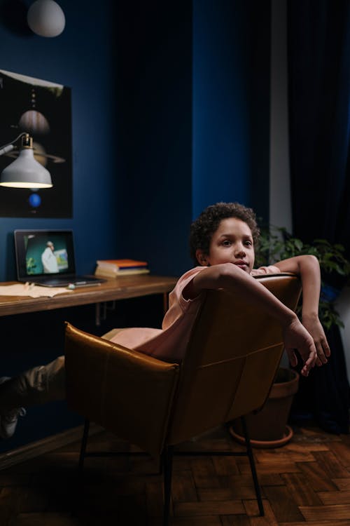 Boy Laying on Brown Leather Armchair