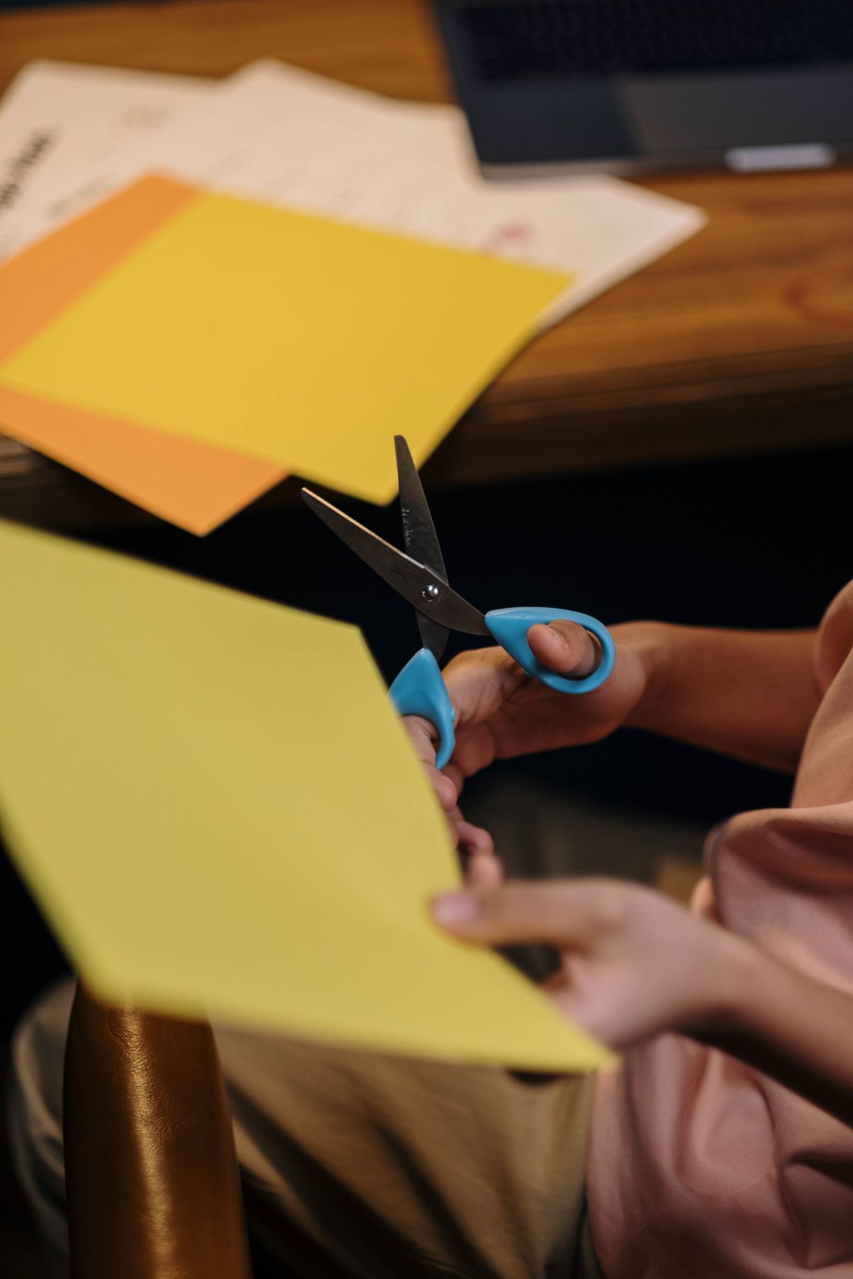 A child cutting colored paper with safety scissors during a craft activity