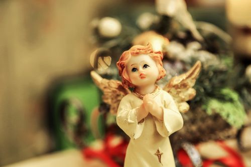 Free Close-up of a delicate angel figurine with a holiday theme and blurred decorative background. Stock Photo