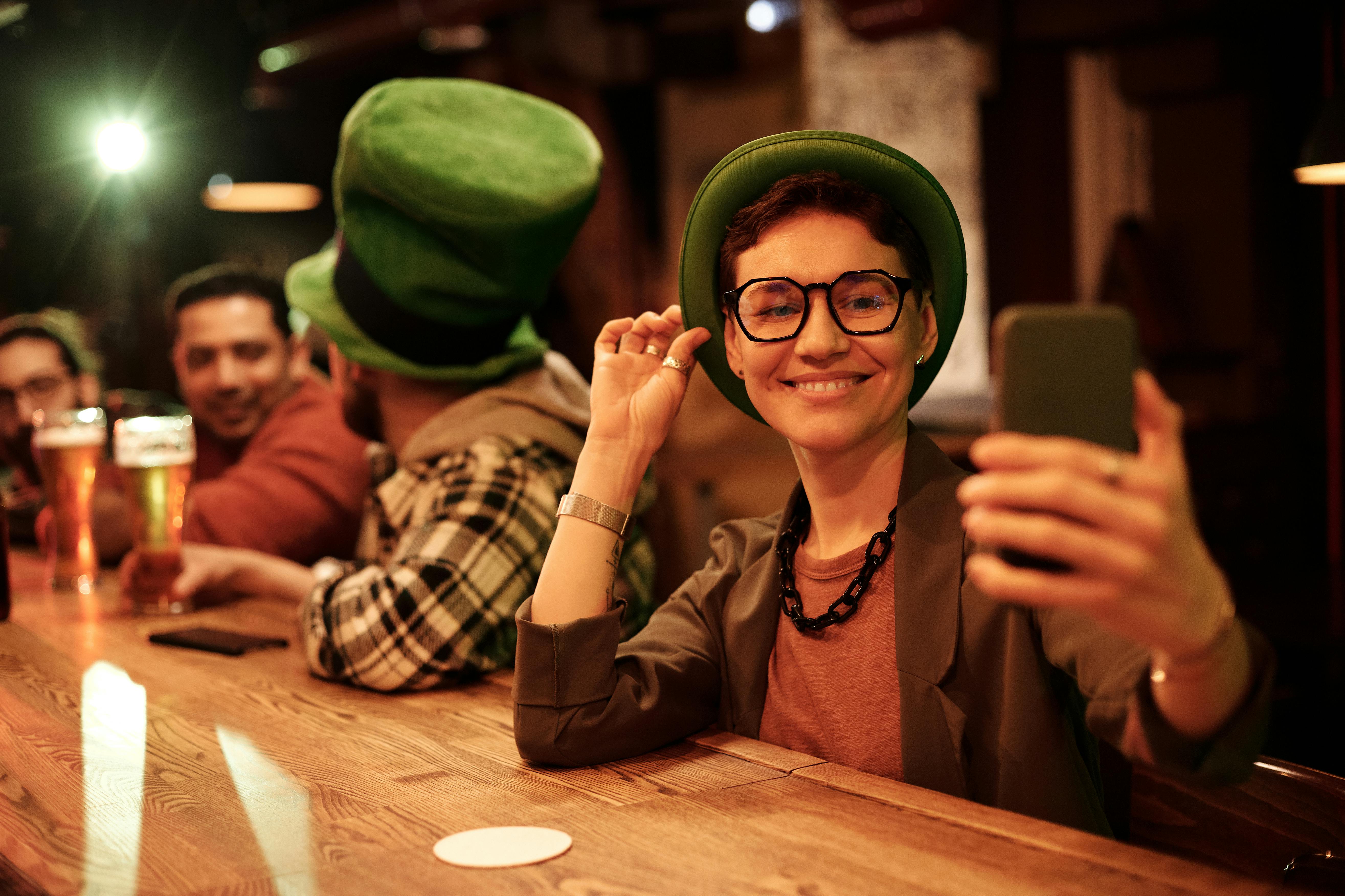 shallow focus of a woman wearing eyeglasses while taking picture of herself using a mobile phone