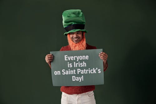 Man in Green Hat Holding a Placard on Green Background 