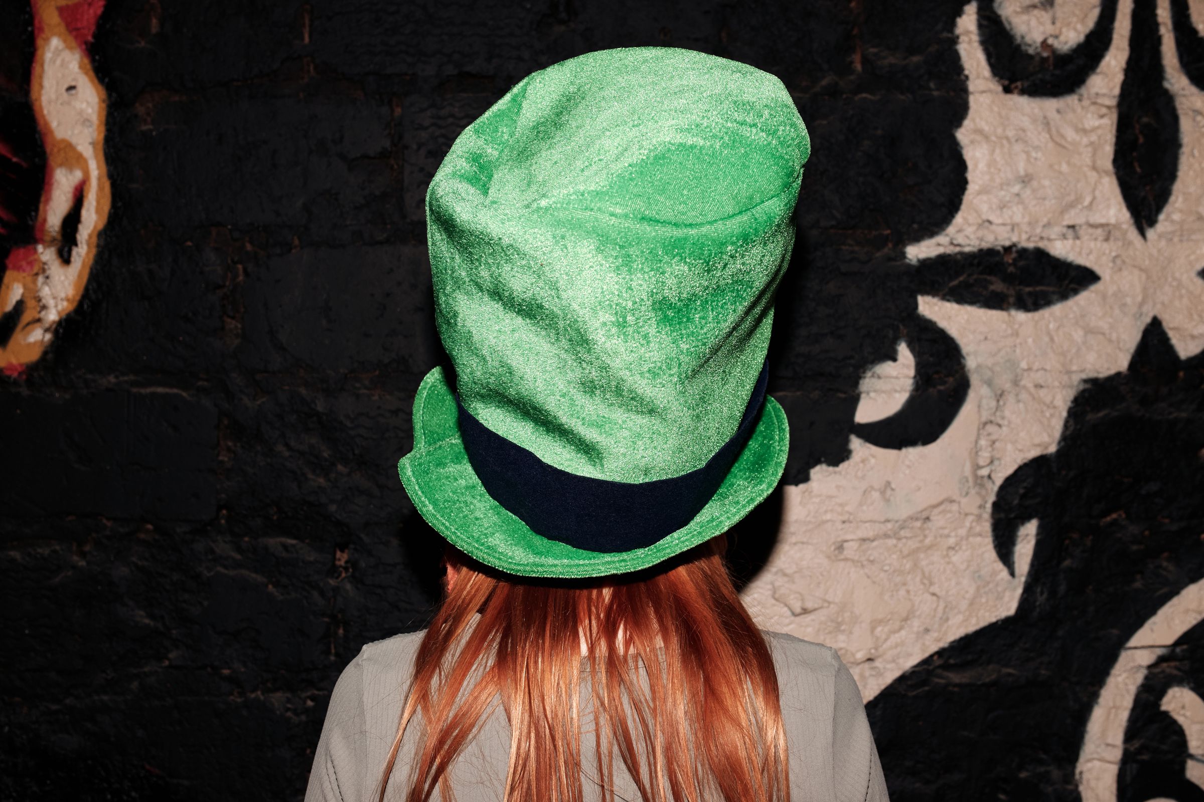 Person wearing festive green shamrock hat for St. Patrick's Day