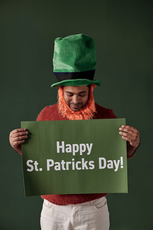 Woman in Green Hat Holding a Placard on Green Background
