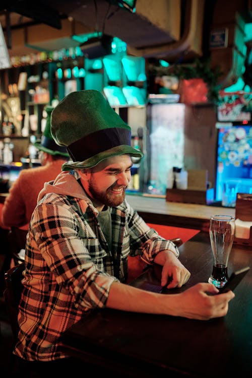 Man wearing Green Hat using Phone 