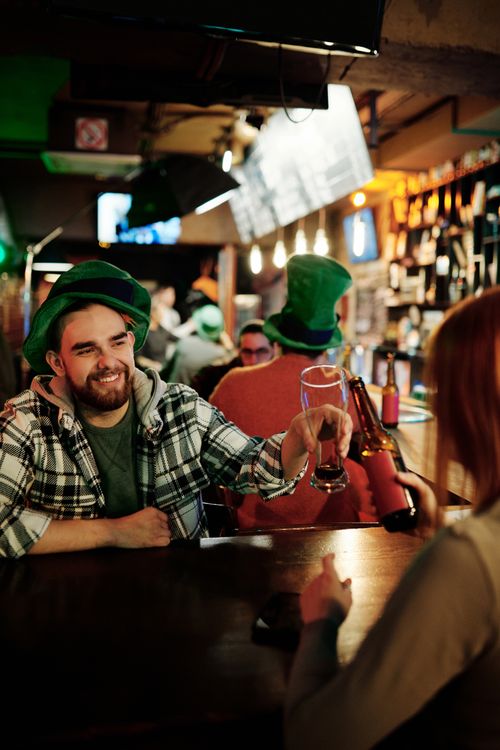 Free Friends enjoying drinks and fun atmosphere on St. Patrick's Day. Stock Photo