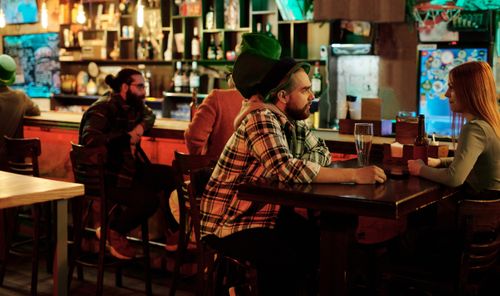 Free People enjoying drinks at a festive Irish bar setting during Saint Patrick's Day. Stock Photo