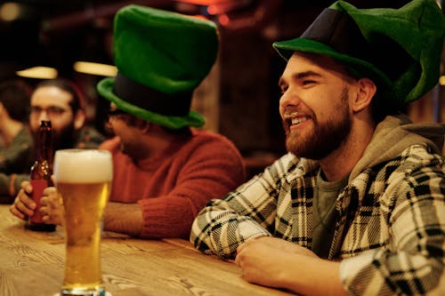 Men Wearing Green Leprechaun Hat Drinking in a Bar