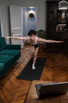A man engages in a focused yoga pose in a living room, balancing strength and concentration.