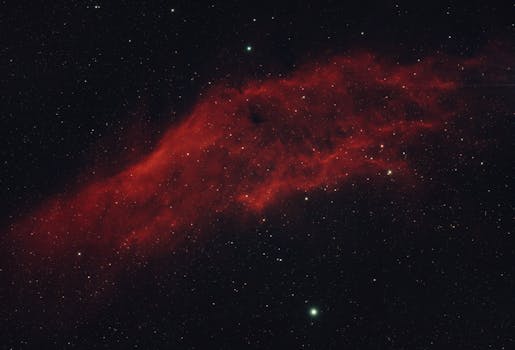 Capture the beauty of a red nebula surrounded by a star-filled universe.