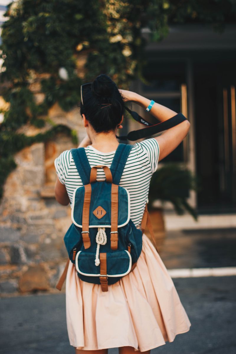 A person walking a bright street with a webbing-strapped pack — photo by Kristina Paukshtite on Pexels