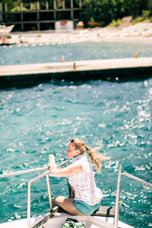 Free Woman enjoying summer while sitting on yacht Stock Photo