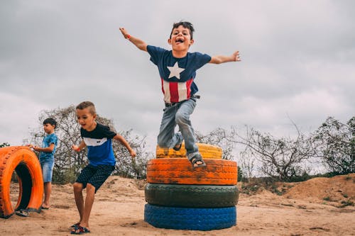 Free Photograph of Kids Playing Near Colorful Tires Stock Photo