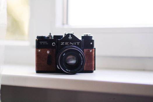 Retro photo camera on windowsill indoors