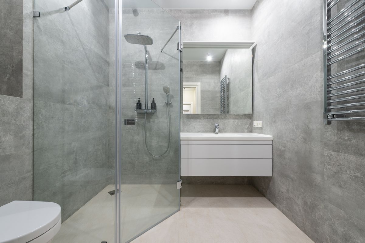 small bathroom with wall hung toilet and glass shower screen