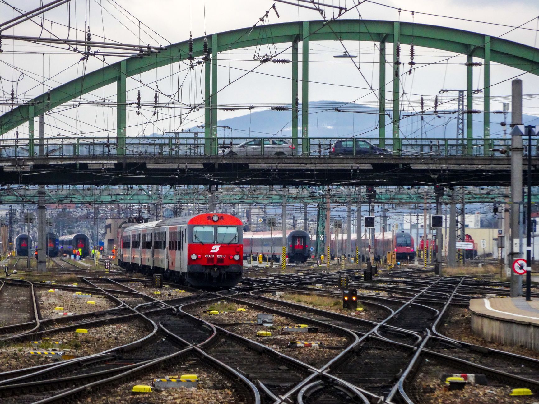 Vienna rail approaches with multiple tracks Trains pulling into Vienna rail approaches under a bridge