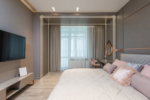 Modern bedroom interior design with soft king size bed with cozy pillows and TV set