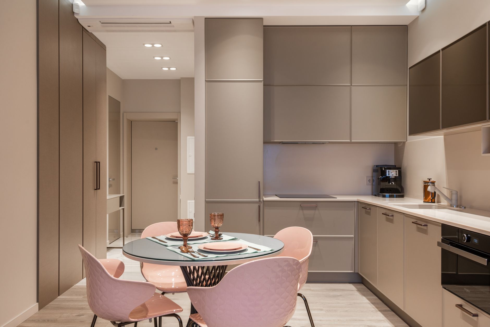 Modern stylish kitchen interior design with empty shelves set dining table and light pink chairs